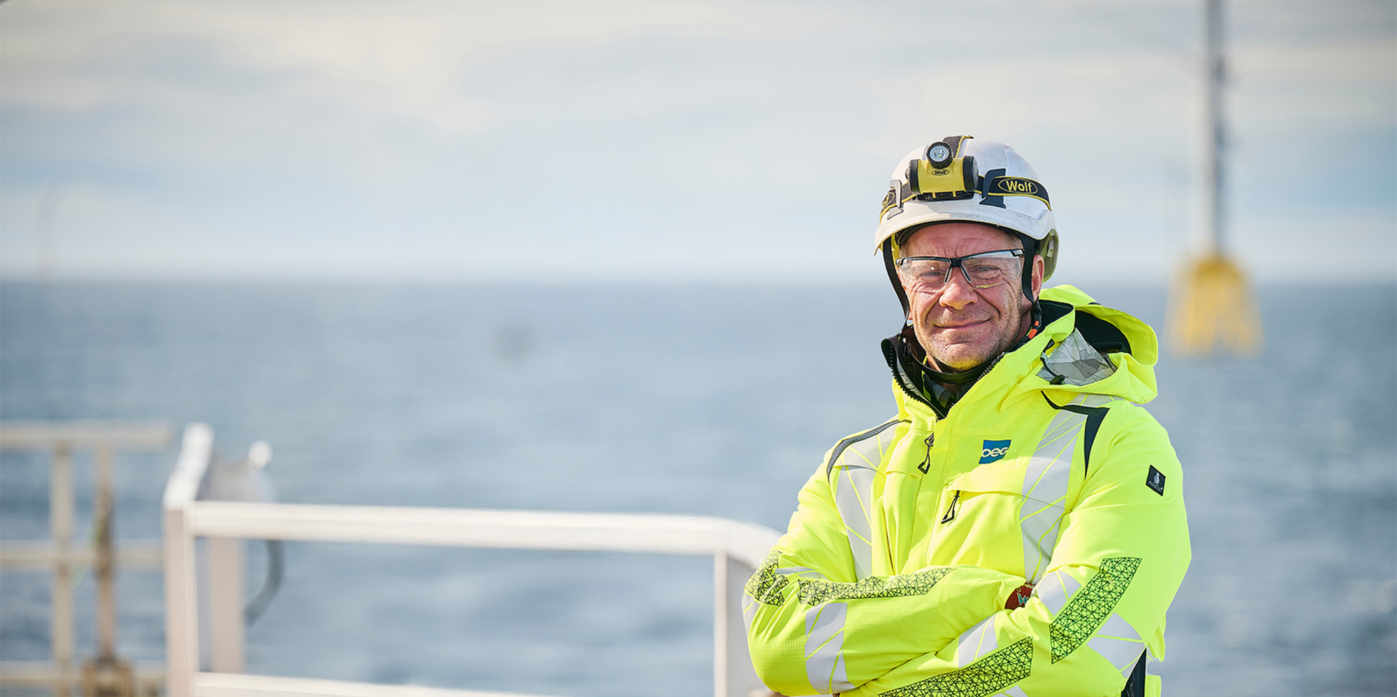 Offshore wind engineer standing with arms folded.