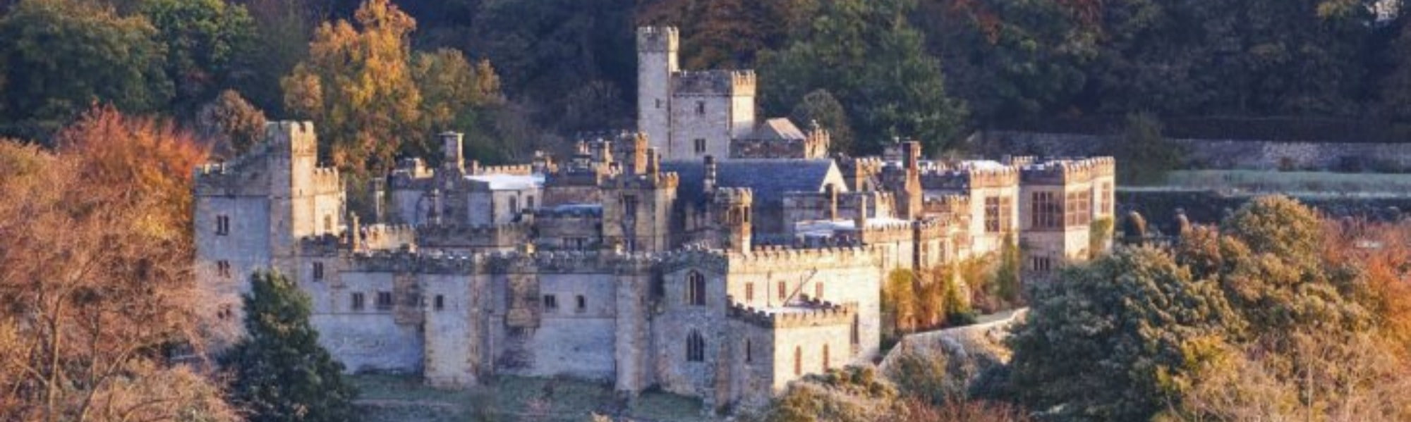 Haddon Hall castle seen from above, nestled among trees. Hiring part-time accountant in Derbyshire.