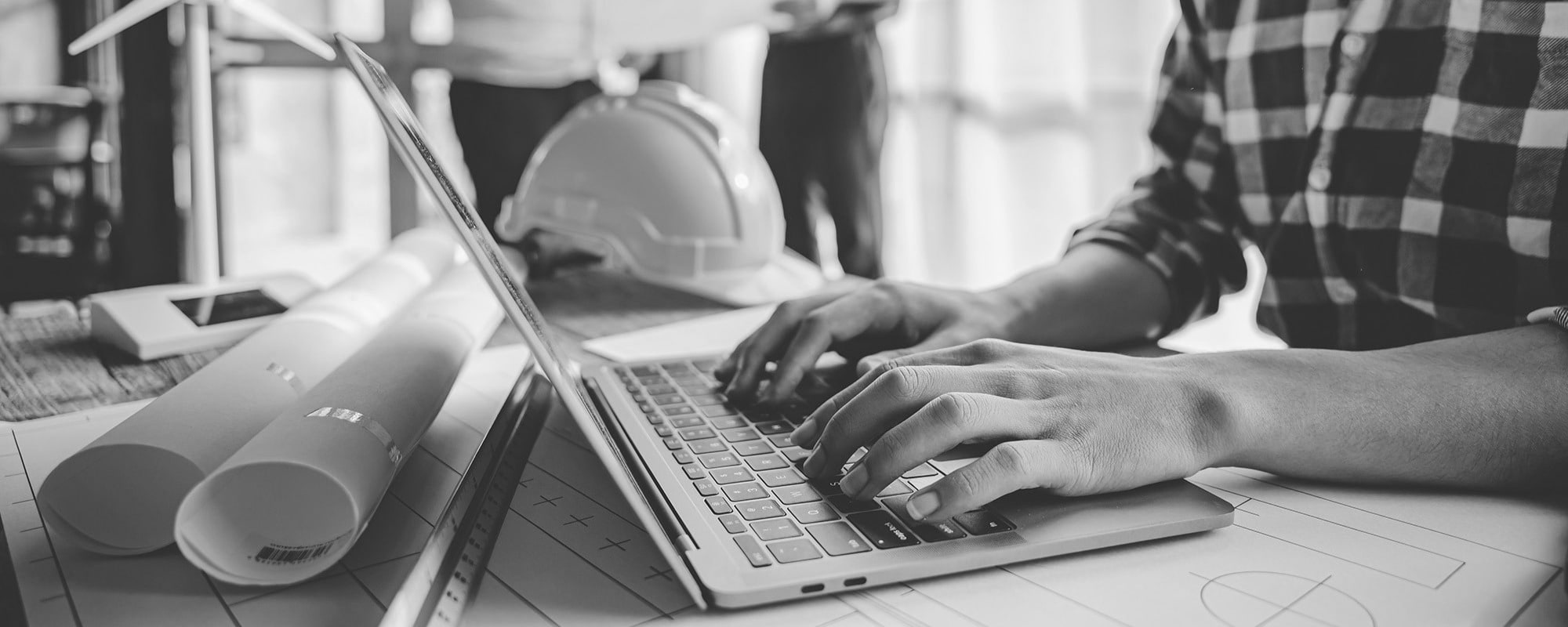 Construction worker typing on laptop
