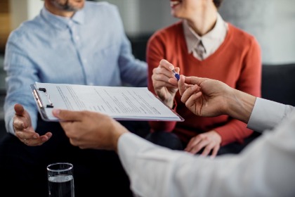 Couple signing insurance papers