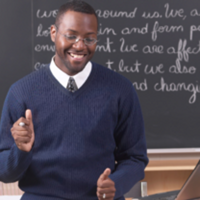 teacher stood in front of a blackboard