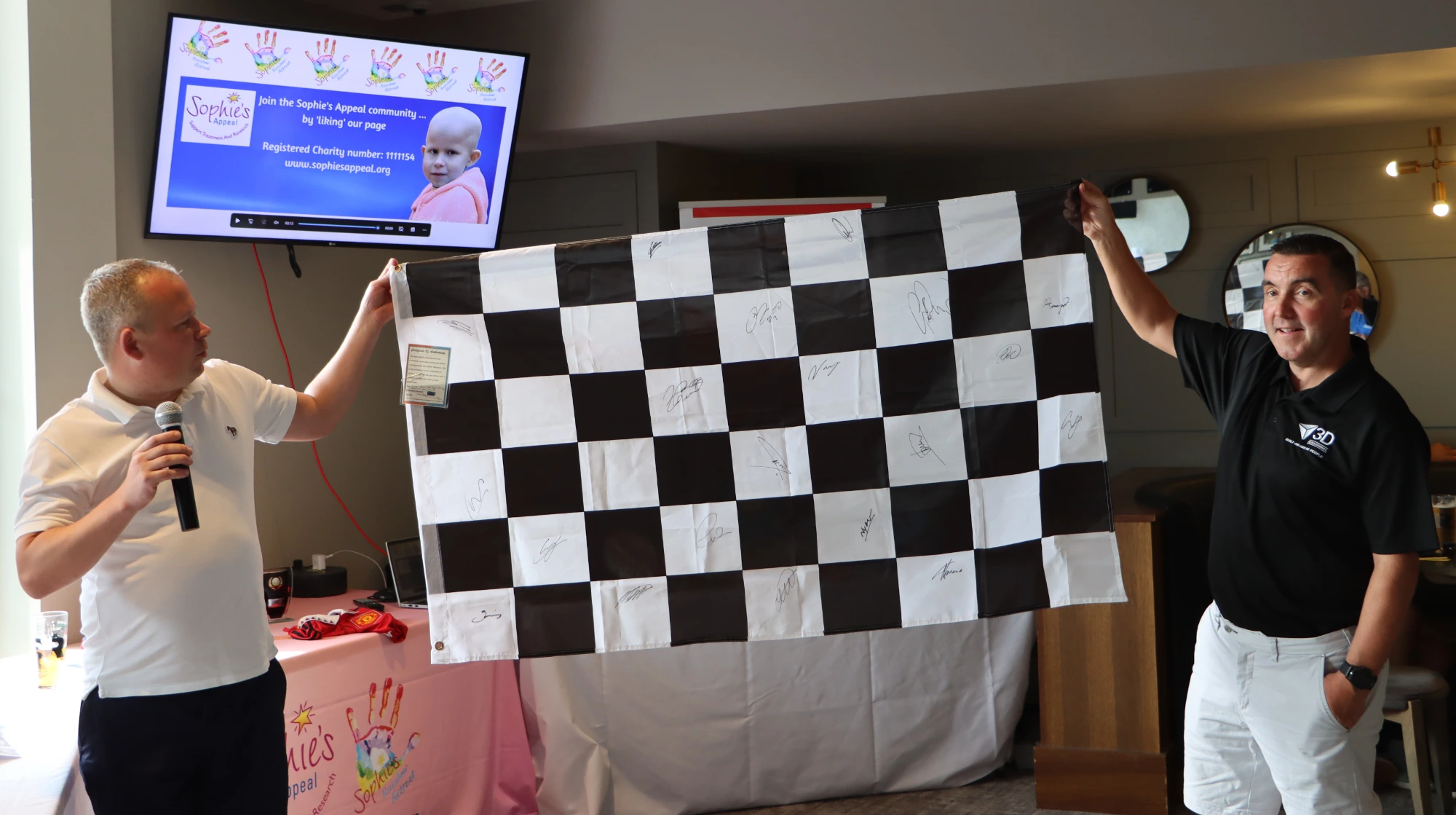 Andy and Damian with the signed F1 Grid Chequered Flag