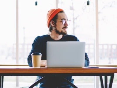 Man with red hat and laptop looking for new job in dev