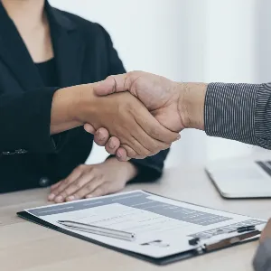 Two people shaking hands at an interview