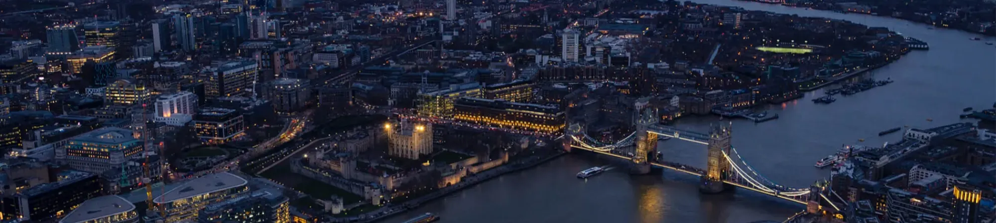 Ariel view of London at night with Tower Bridge and River Thames