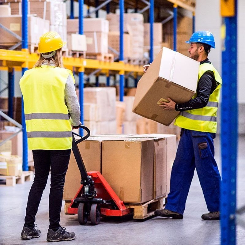 Employees moving and lifting boxes in a warehouse