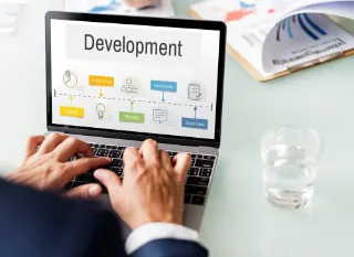 Businessman working on a laptop displaying a development concept on the screen, focused on his task.
