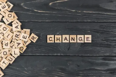 The word "change" formed from wooden blocks on a black background, symbolising career transitions.