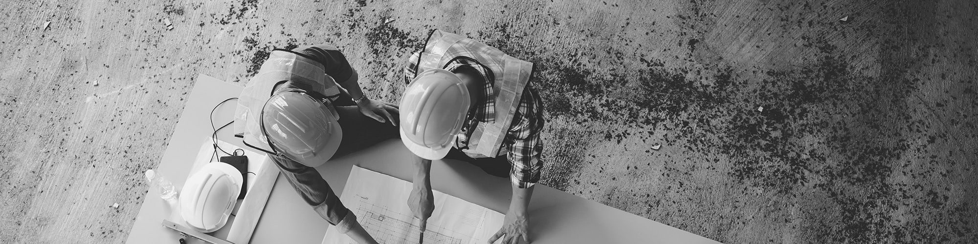 Two construction workers looking over construction plans