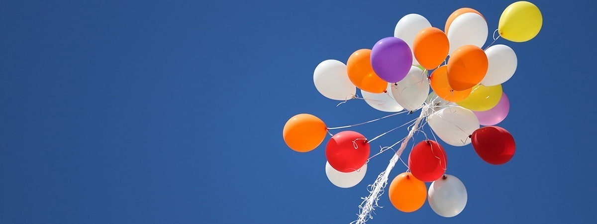 Multi-coloured balloons all competing for the blue sky